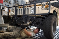 Senior Airman Nicholas Ezzo unchains a Humvee from a C-17 Globemaster lll aircraft.