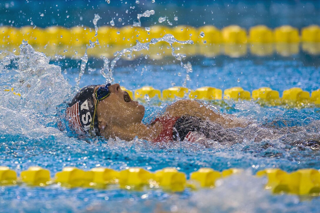 An athlete swims backstroke.