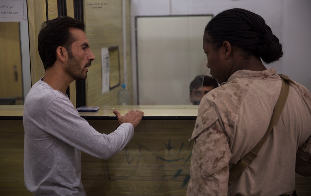 The bank manager at 1st Brigade shows a U.S. Marine advisor with Task Force Southwest how the soldiers withdraw money at 1st Brigade, near New Garm Ser, Afghanistan, Sept. 23, 2017. The advisor wanted to address shortfalls, if any, to allow a smoother process for the soldiers. As part of the new U.S. South Asia strategy, Marines are advising down to the brigade- and kandak-levels where necessary to support Afghan National Defense and Security Force operations. (U.S. Marine Corps photo by Sgt. Justin T. Updegraff)