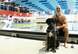 U.S. Coast Guard Petty Officer 1st Class Rob Troha, an intelligence specialist and member of Team U.S. at the 2017 Invictus Games poses with his service dog Gauge, moments after his swimming event at the Pan Am Sports Centre Toronto, Canada Sept. 28, 2017. Troha, who suffers from a degenerative brain disorder, also competed in seated discus and shotput in this year’s games. (U.S. Air Force photo by Staff Sgt. Chip Pons)