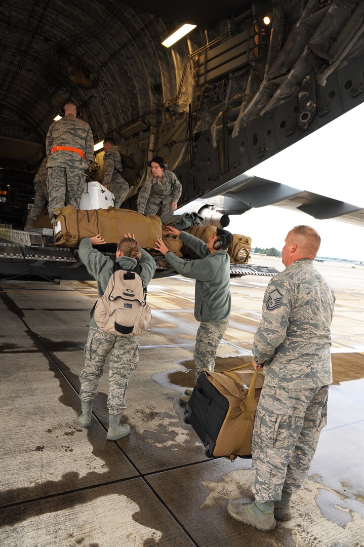 Oregon Air National Guard members from the 142nd Communication Flight load their personal bags on a C-17 Globemaster III, at the Portland Air National Guard Base, Ore., Sept. 29, 2017. The Eight member team is deploying to support Hurricane Maria relief efforts in Puerto Rico.