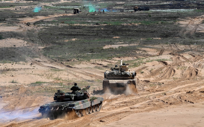 U.S. Marine Corps and Polish military members operate an M1 Abrams and Leopard 2 tank