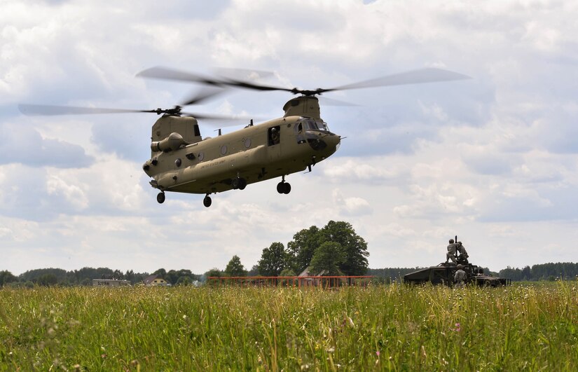 A U.S. Army CH-47 Chinook helicopter flies towards Airmen