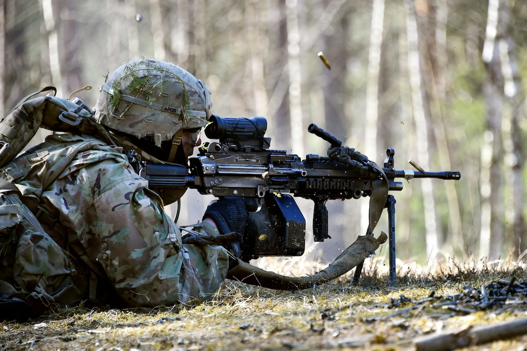 A soldier fires a M249 light machine gun.