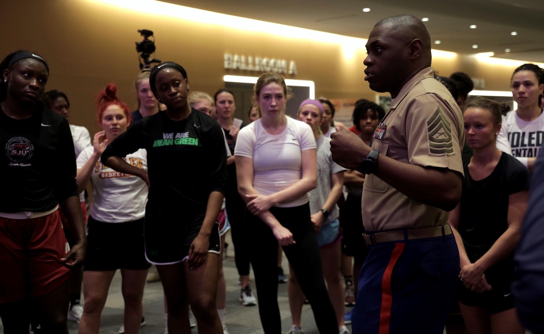 Columbus, Ohio — Master Sgt. Damian Cason speaks to coaches and student athletes who attended the Women’s Basketball Coaches Association (WBCA) Convention about the Marine Corps’ valuable partnership with the WBCA after they participated a wake up and workout session at the Greater Columbus Convention Center, Columbus, Ohio, March 30, 2018. Marines attended the WBCA to engage with women of all experience levels and inform them about opportunities within the Corps. This year, the Marine Corps celebrates 100 years since women first joined the Corps, an anniversary celebrated for the progress of women who now have the ability to join any occupational specialty within the Marines. (U.S. Marine Corps photo by Lance Cpl. Naomi Marcom)