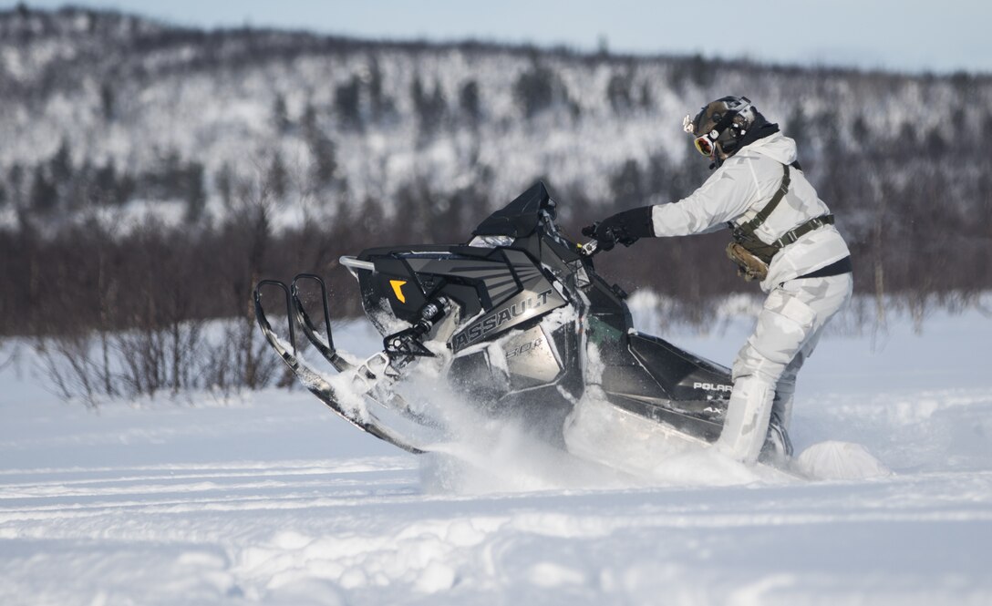 A soldier maneuvers on a snowmobile