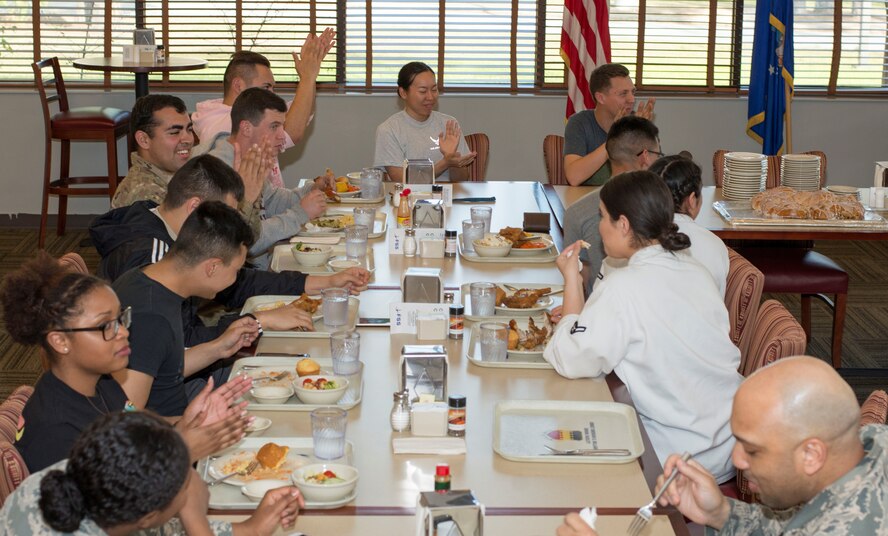 Team Shaw Airmen eat while encouraging a wingman to complete a game at the Chief Master Sgt. Emerson Williams Dining Facility at Shaw Air Force Base, S.C., March 28, 2018.