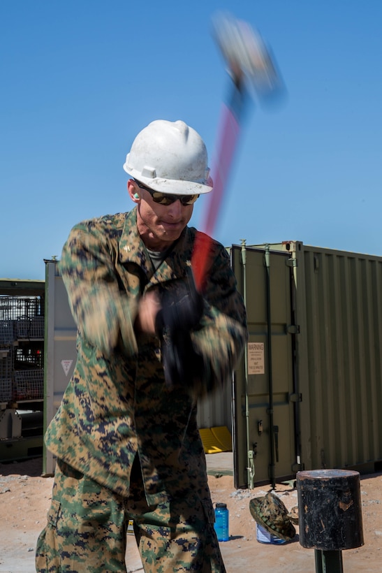 Maj. Sean Hulsey, a Marine Wing Support Squadron 473 airfield operations company commander, hammers a spike into the ground during airfield damage repair operations in support of Weapons and Tactics Instructor Course 2-18 at Canon Air Defense Complex, Yuma, Ariz., March 28.