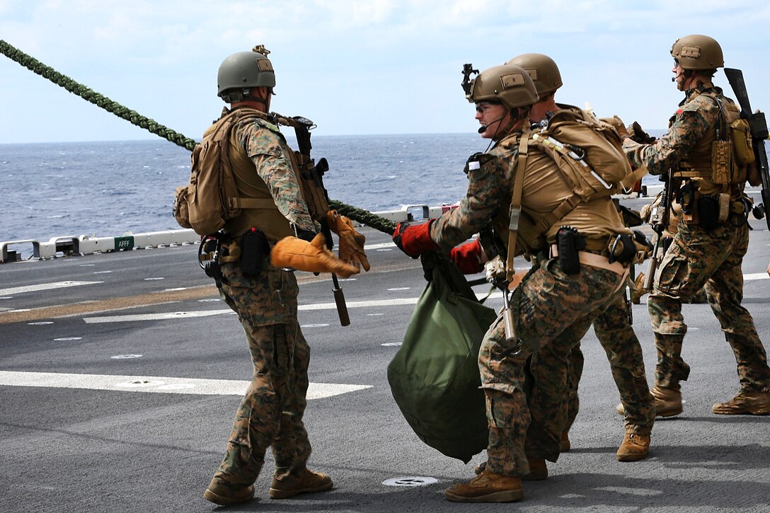 Marines unsecure a rope after conducting fast-rope training.