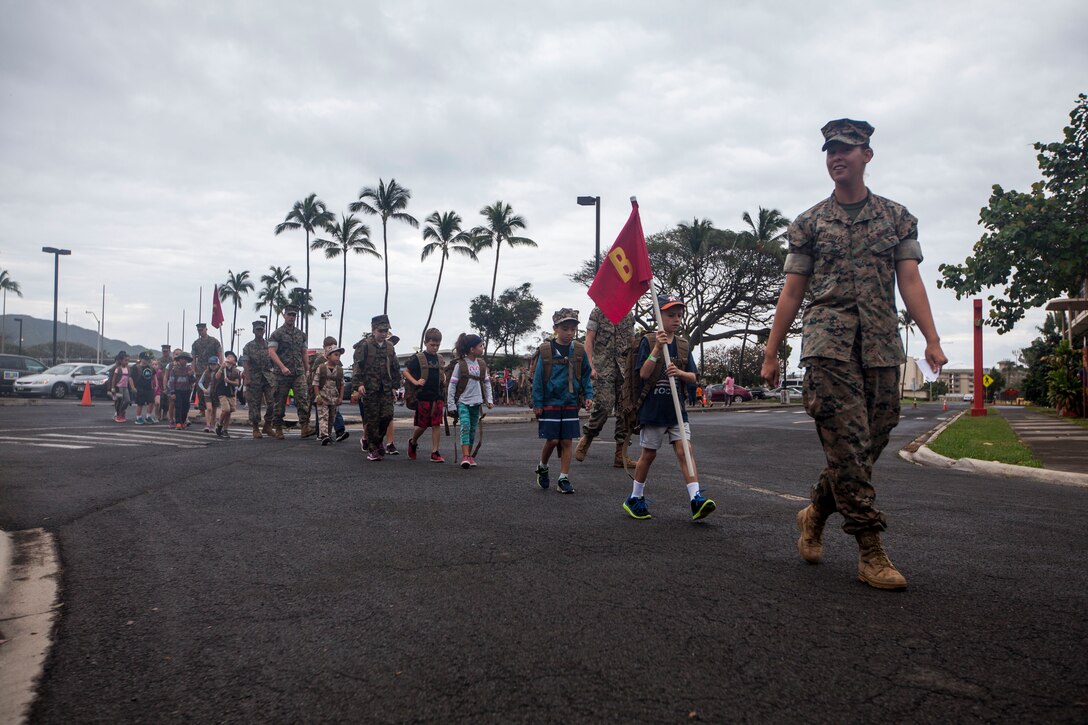 Lance Cpl. Robyn Lebuffe, a military police officer with the Provost Marshal’s Office, Marine Corps Base Hawaii (MCBH), leads her group to their next station during ‘Operation Ooh-Rah Kids’, MCBH, March 23, 2018. MCBH Marines and Sailors volunteer each year to give the children a chance to experience what it’s like to be a Marine. (U.S. Marine Corps photo by Lance Cpl. Matthew Kirk)
