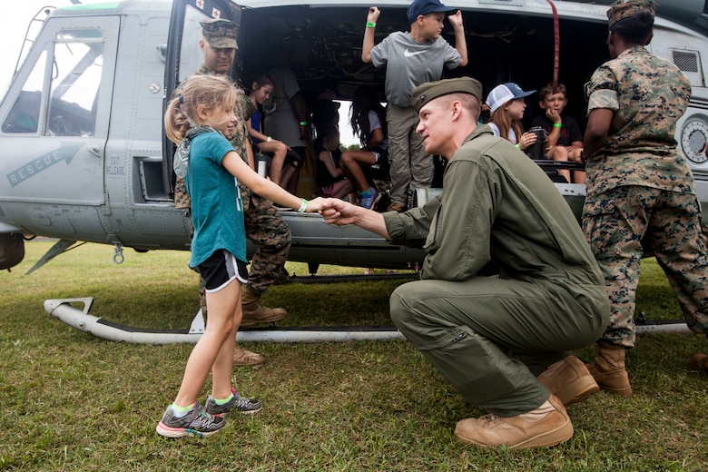 Capt. Matthew Dieska, a UH-1Y Venom helicopter pilot with Marine Light Attack Helicopter Squadron 367, Marine Aircraft Group 24, introduces himself to a child during ‘Operation Ooh-Rah Kids’, Marine Corps Base Hawaii (MCBH), March 23, 2018. MCBH Marines and Sailors volunteer each year to give the children a chance to experience what it’s like to be a Marine (U.S. Marine Corps photo by Lance Cpl. Matthew Kirk)