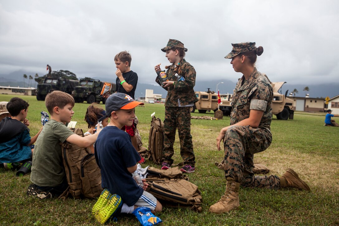 Lance Cpl. Robyn Lebuffe, a military police officer with the Provost Marshal’s Office, Marine Corps Base Hawaii (MCBH), sits with her group of children while they take a lunch break during ‘Operation Ooh-Rah Kids’, MCBH, March 23, 2018. MCBH Marines and Sailors volunteer each year to give the children a chance to experience what it’s like to be a Marine. (U.S. Marine Corps photo by Lance Cpl. Matthew Kirk)