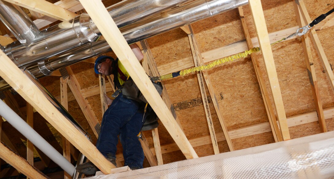 Ronnie Woods, a heating ventilation and cooling technician contracted by the Department of Defense, walks across rafters at Ellsworth Air Force Base, S.D., March 26, 2018. The new dormitories began construction January 2017 and are projected to be completed January 2019 at a cost of approximately $21.5 million. (U.S. Air Force photo by Airman 1st Class Thomas Karol)
