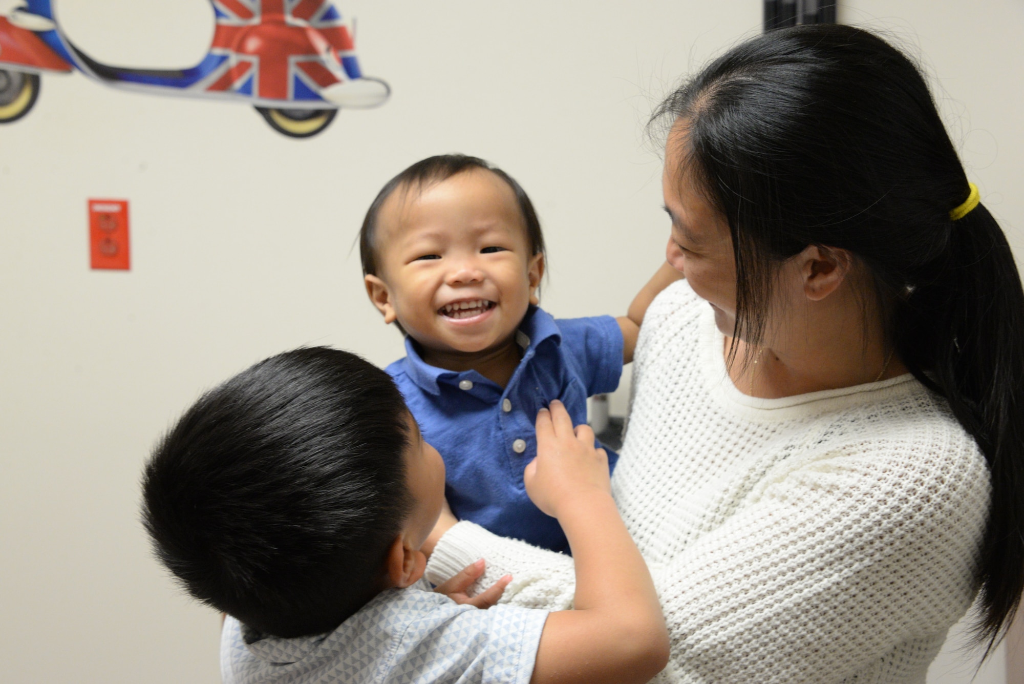 Levi, center, is held by his mother, Jolene Abaya, and comforted by his big brother, Roen, March 30, 2018, before a check-up at the David Grant USAF Medical Center Pediatric Clinic at Travis Air Force Base, Calif. The Pediatric Clinic cares for 4,500 military children from newborns up to 18 years old. (U.S. Air Force photo by Staff Sgt. Amber Carter).