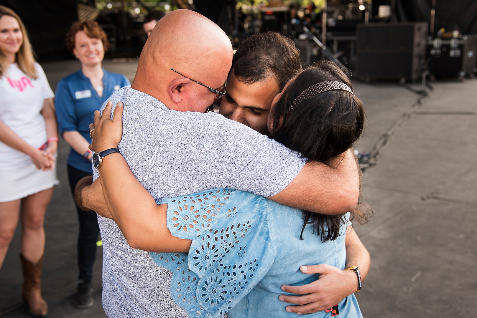 U.S. Air Force Senior Airman Jonathan Rodriguez-Maldonado, 502d Comptroller Squadron finance technician is reunited with his parents during the NCAA March Madness Final Four Music Festival on March 31, 2018. Before he could visit his family in Puerto Rico, following a deployment to Kuwait, Hurricane Maria struck the island, leaving him unable to visit his family. (U.S. Air Force photo by Senior Airman Gwendalyn Smith)