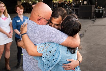 U.S. Air Force Senior Airman Jonathan Rodriguez-Maldonado, 502d Comptroller Squadron finance technician is reunited with his parents during the NCAA March Madness Final Four Music Festival on March 31, 2018. Before he could visit his family in Puerto Rico, following a deployment to Kuwait, Hurricane Maria struck the island, leaving him unable to visit his family. (U.S. Air Force photo by Senior Airman Gwendalyn Smith)