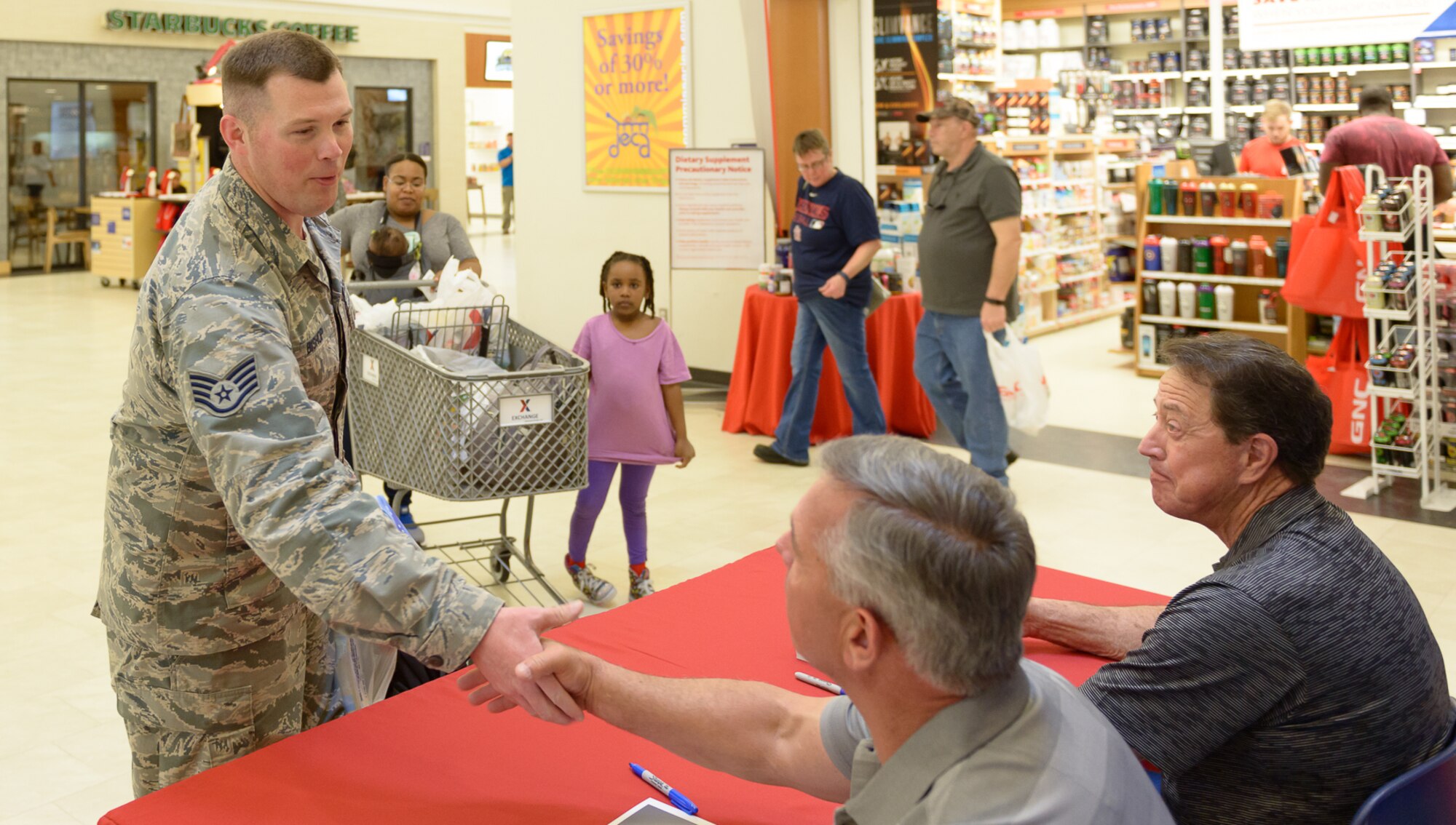 U.S. Air Force Staff. Sgt. Brian Bishop, 85th Engineering Installation Squadron radio frequency transmissions technician, shakes hands with Jeff Hammond during the meet and greet at The Exchange March 30, 2018, on Keesler Air Force Base, Mississippi. Hammond and Gant spent the day meeting veterans at the Armed Forces Retirement Home and toured various facilities that support veterans on Keesler Air Force Base. Gant is a former NASCAR driver and Hammond is a current TV broadcaster for the motorsport.