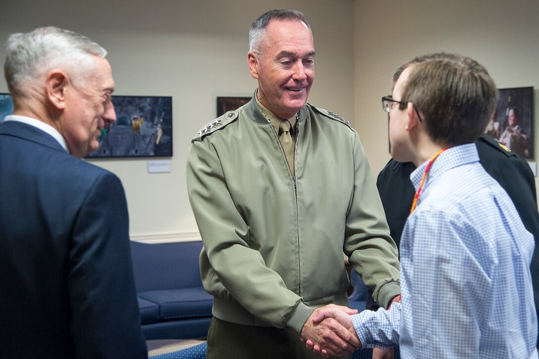 Marine Corps Gen. Joe Dunford, chairman of the Joint Chiefs of Staff, shakes hands with a civilian.