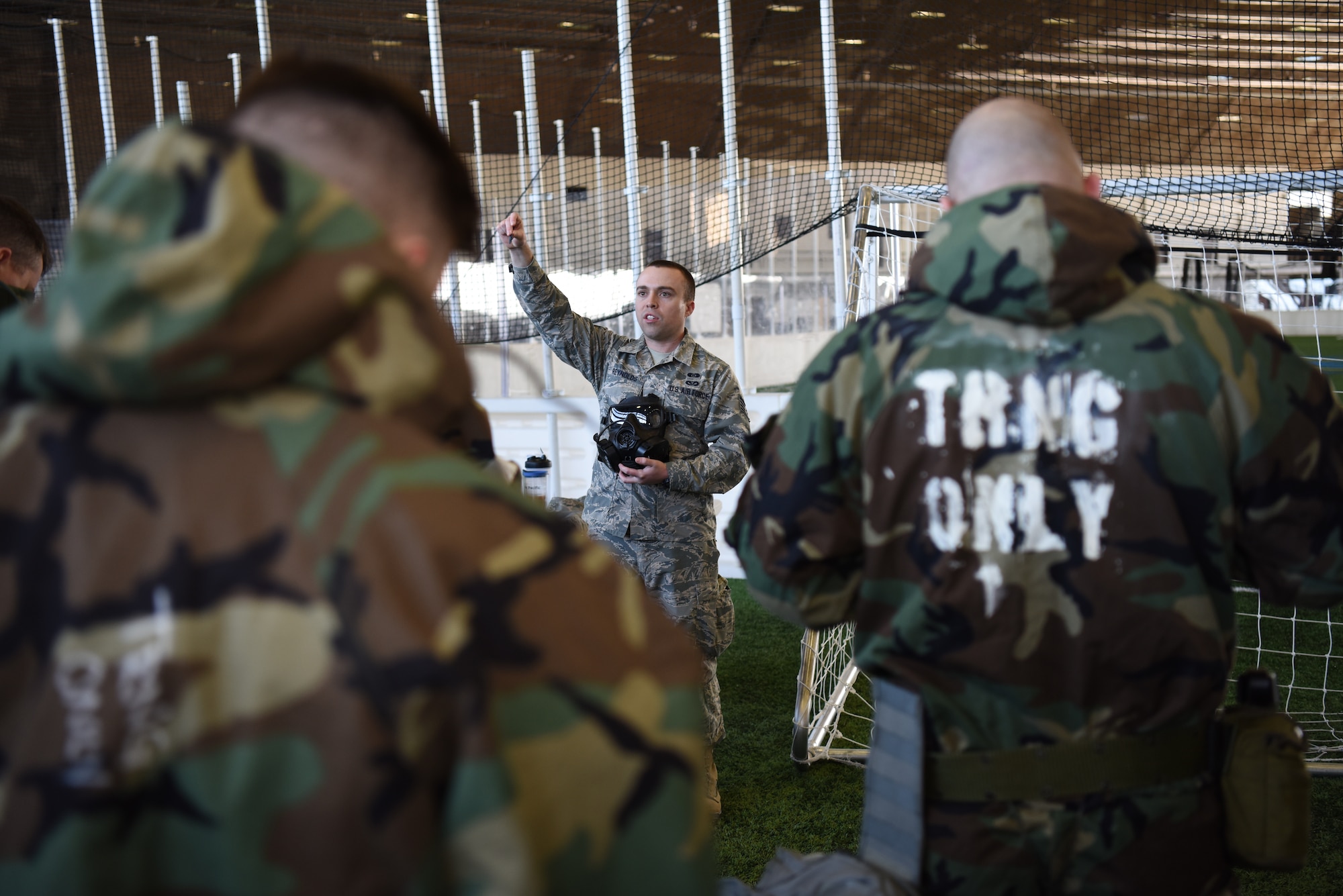 Staff Sgt. Ronald Reynolds, a 28th Civil Engineer Squadron emergency management technician, instructs Airmen on the fundamentals of a gas mask during chemical, biological, radiological, nuclear and environmental training at Ellsworth Air Force Base, S.D., March 14, 2018. During the course, instructors demonstrated how to properly store and wear mission oriented protective posture gear, cover military assets, and test surfaces for chemical agents. (U.S. Air Force photo by Airman 1st Class Donald C. Knechtel)