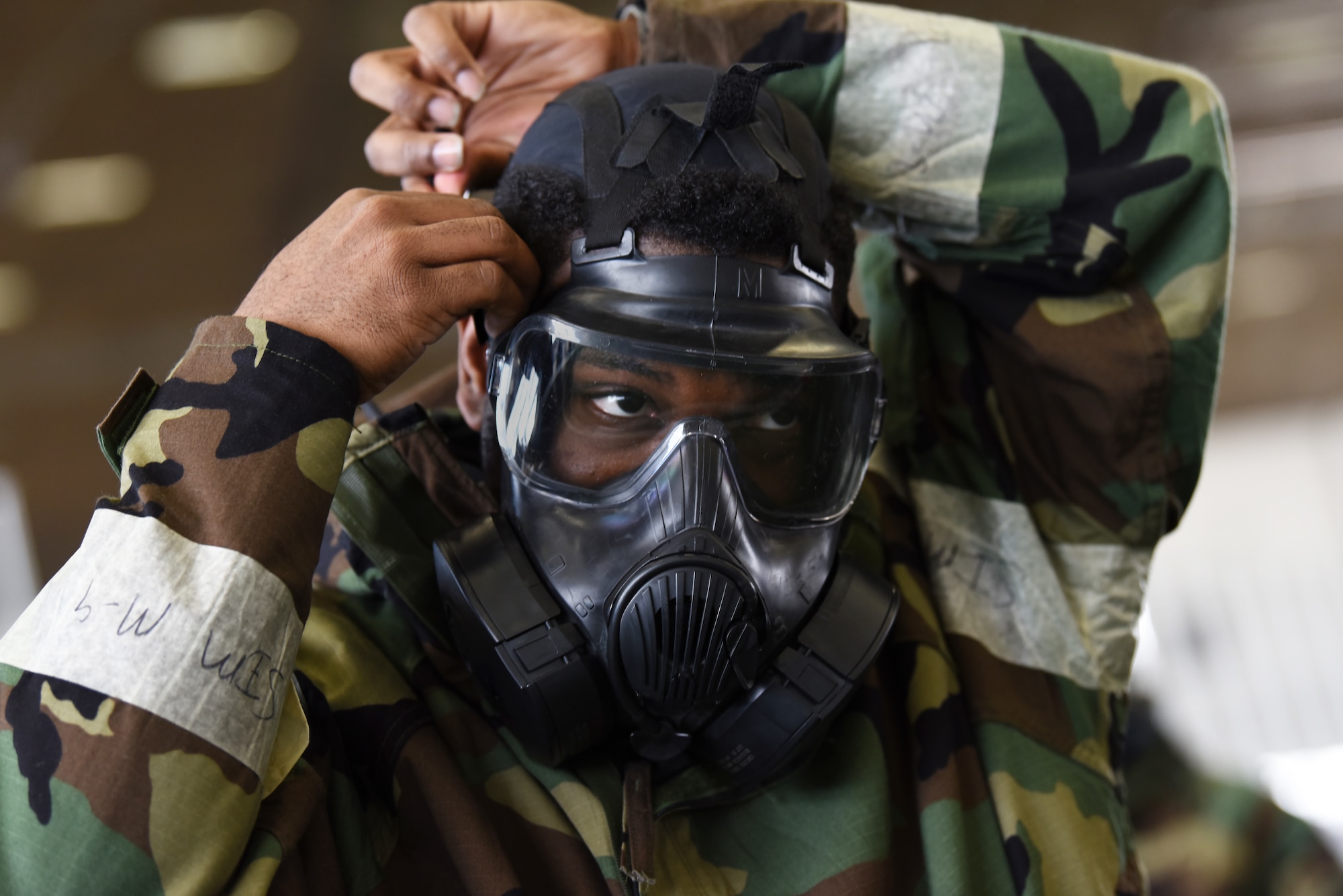 Airman 1st Class Kimani Petersen, a 28th Maintenance Squadron aerospace ground equipment technician, quickly dons his gas mask during chemical, biological, radiological, nuclear and environmental training at Ellsworth Air Force Base, S.D., March 23, 2018. During the course, students learned to properly store and wear mission oriented protective posture gear, cover military assets and test surfaces for chemical agents. (U.S. Air Force photo by Airman 1st Class Donald C. Knechtel)