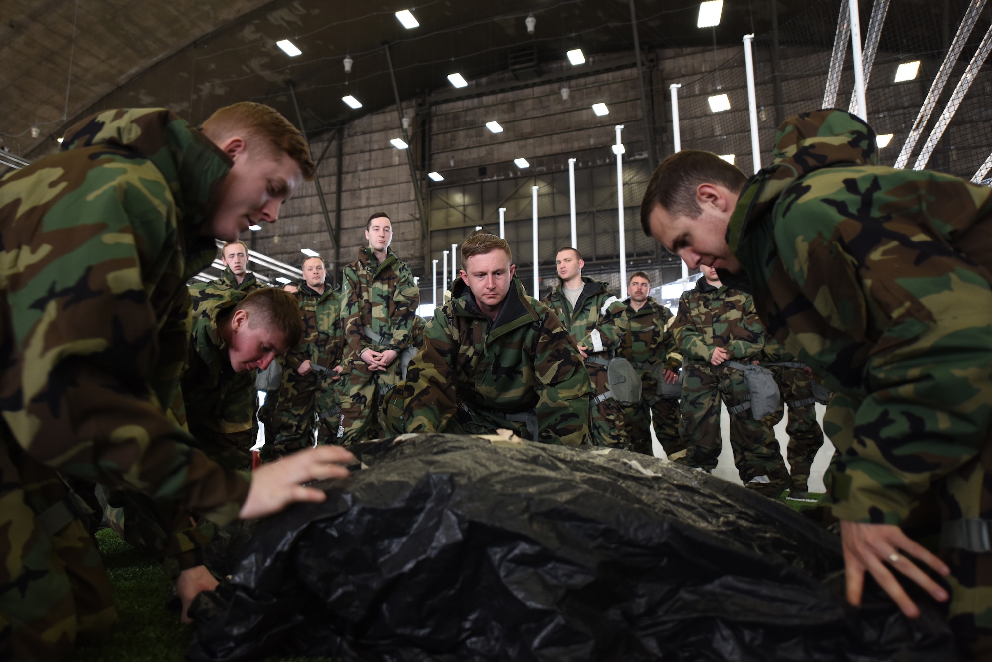 Airmen cover military assets and mark them during chemical, biological, radiological, nuclear and environmental training at Ellsworth Air Force Base, S.D., March 23, 2018. During the course, students learned to properly store and wear mission oriented protective posture gear, cover military assets, and how to test surfaces for chemical agents. (U.S. Air Force photo by Airman 1st Class Donald C. Knechtel)