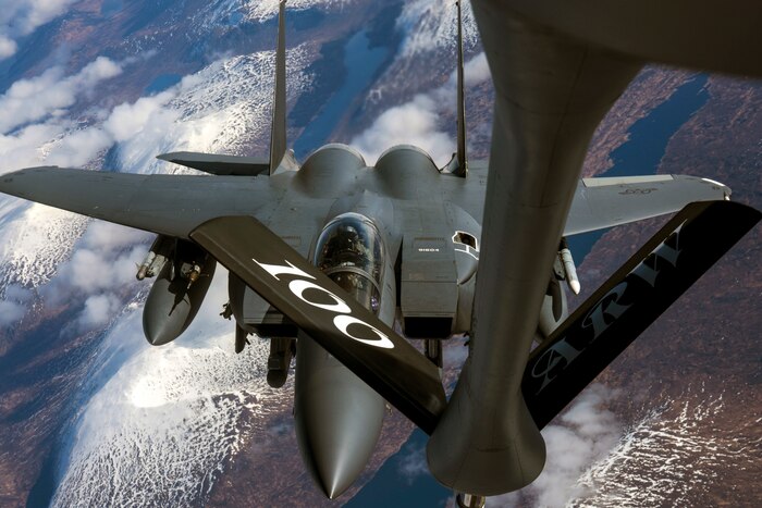 A jet receives fuel from the boom of another aircraft while in flight.