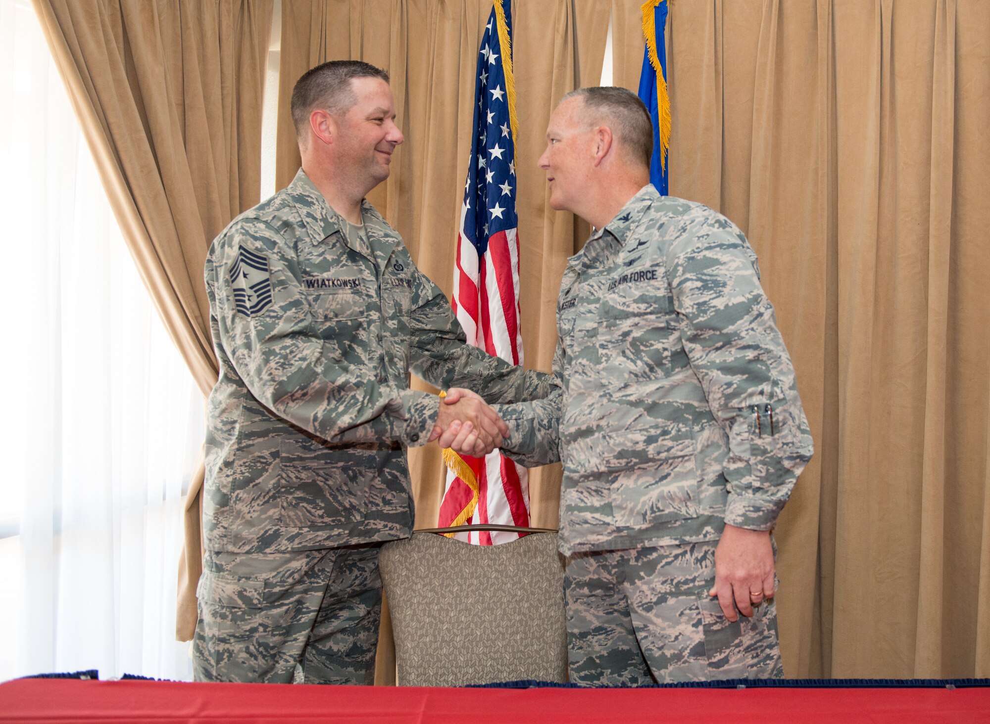 Chief Master Sgt. Randy Kwiatkowski, 56th Fighter Wing command chief, and Col. Robert Sylvester, 56th Mission Support Group commander, shake hands after signing the Air Force Assistance Fund donation forms during the AFAF campaign kickoff breakfast at Luke Air Force Base, Ariz., April 2, 2018. The event officially started the six-week campaign at Luke, designed to provide support to Air Force personnel and their families. (U.S. Air Force photo by Airman 1st Class Alexander Cook)