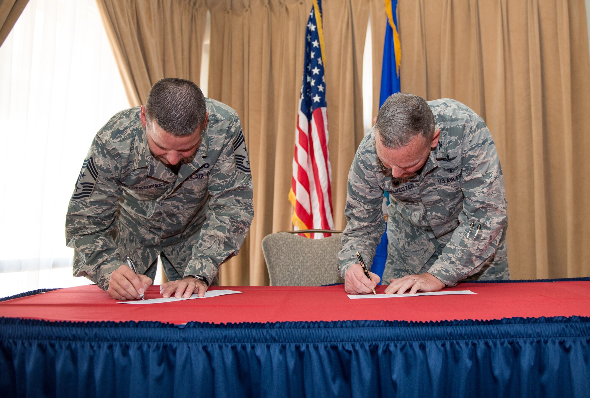 Chief Master Sgt. Randy Kwiatkowski, 56th Fighter Wing command chief, and Col. Robert Sylvester, 56th Mission Support Group commander, sign the Air Force Assistance Fund donation forms during the AFAF campaign kickoff breakfast at Luke Air Force Base, Ariz., April 2, 2018. Kwiatkowski and Sylvester made their initial contributions to the AFAF, officially starting the six-week campaign at Luke. (U.S. Air Force photo by Airman 1st Class Alexander Cook)
