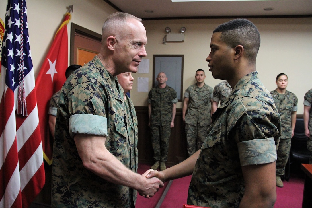 Maj. Gen. Patrick J. Hermesmann (left), commander of U.S. Marine Corps Forces Korea, congratulates Lance Cpl. Elijah A. Williamson, MARFORK G-5 Plans and Policy clerk, after promoting him to his current rank here, April 2.  According to Hermesmann, Williamson has received considerable accolades for his work in supporting the command’s mission. (Official U.S. Marine Corps photo by Sgt. Nathaniel Hanscom/Released)
