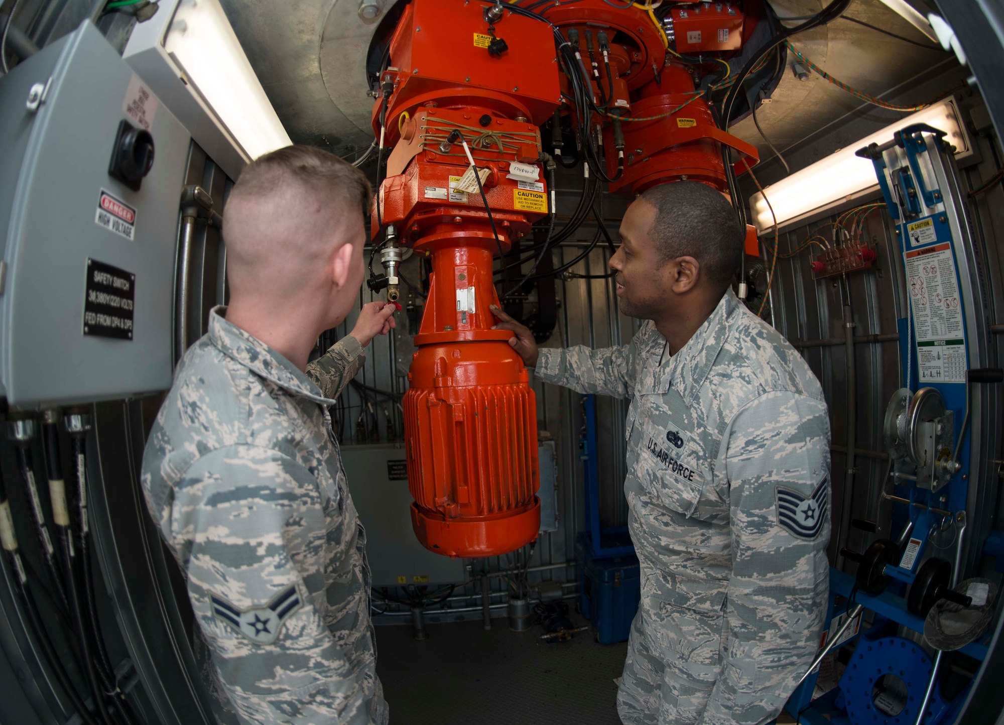 U.S. Air Force Airman 1st Class Connor Murph, left, 86th Operations Support Squadron Air Traffic Control and Landing Systems radar, airfield, and weather systems technician, and Tech. Sgt. Jerel Sledge, RAWS production control noncommissioned officer in charge, observe the primary engine which turns the radar dish at the digital airport surveillance radar tower on Ramstein Air Base, Germany, Mar. 14, 2018. No matter the weather, day and night, the 86th OSS ATCALS team ensures that when pilots need guidance on and off the flightline, the systems in place are ready. (U.S. Air Force photo by Senior Airman Elizabeth Baker)