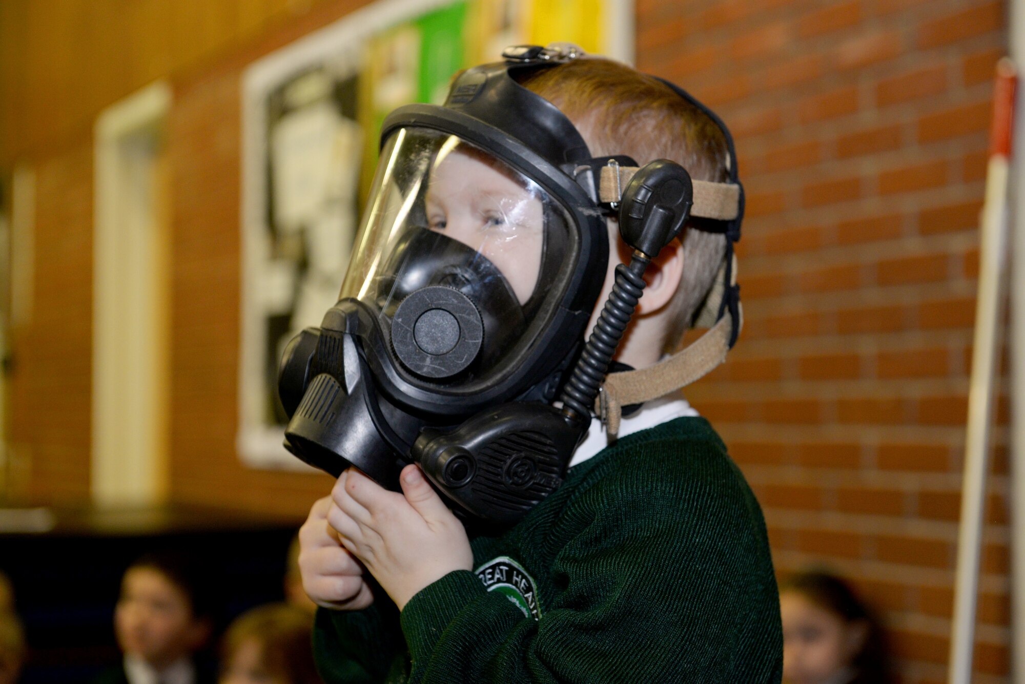A young student from Great Heath Academy tries on firefighter gear from the 100th Civil Engineer Squadron Fire Department during a school visit in Mildenhall, England, March 27, 2018. The firefighters showed the children what their gear is used for, explained how it protects them and allowed the children to try on the gear. (U.S. Air Force photo by Airman 1st Class Alexandria Lee)