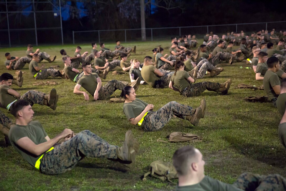 Marine, sailors perform the mason twist exercises.