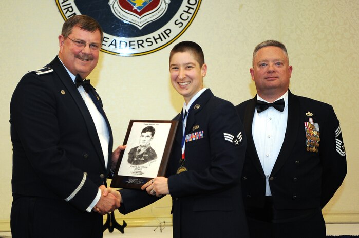 Col. Gregory Gilmour, left, 315th Airlift Wing commander, and Chief Master Sgt. Gwen R. Crabtree, 38th Aerial Port Squadron superintendent, present Senior Airman Nicole Cassidy, 437th Aircraft Maintenance Squadron member, a plaque for earning the John L. Levitow Award during the class 18-C Airman Leadership School Graduation at the Charleston Club here March 29, 2018.