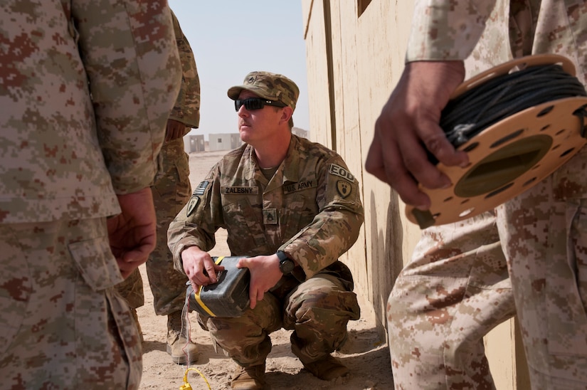 Army Staff Sgt. Zachary Zalesny, an explosive ordnance disposal technician with the 797th Ordnance Company, discusses techniques to defeat improvised explosive devices during a joint training exercise with Kuwait Land Force officers at Udari Range Complex near Camp Buehring, Kuwait, March 22, 2018. Army photo by Sgt. David L. Nye