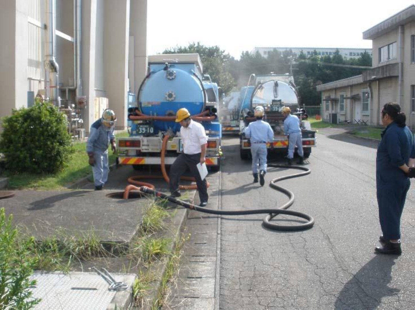 Contractors pump used foam making material from a hangar’s fire suppression system out of the catch basins into their vacuum tank trucks to transport for disposal.