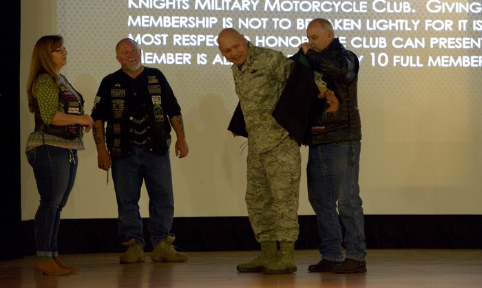 U.S. Air Force Col. Jimmy Canlas, 437th Airlift Wing commander, receives a vest from the 37th chapter of Green Knights during the annual motorcycle rider’s briefing March 30, 2018, at the Air Base Theater.