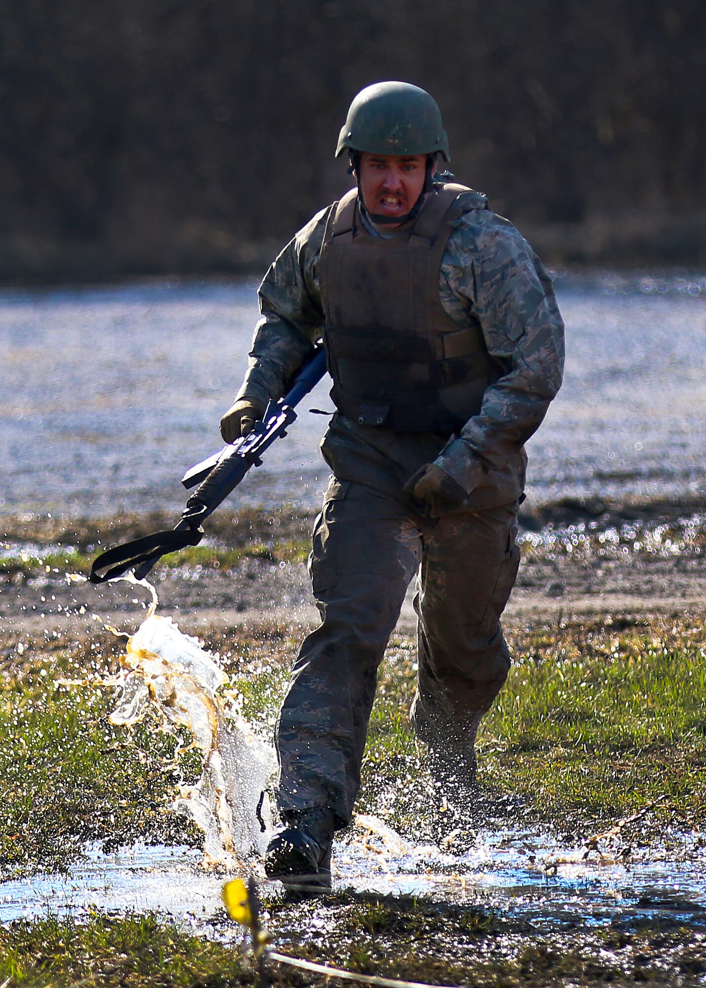 Staff Sgt. Anthony Wilson, 445th Security Forces Squadron, runs through mud and grass as he prepares to go into a low crawl during the 2018 Winter Challenge held during the March 2, 2018 unit training assembly.