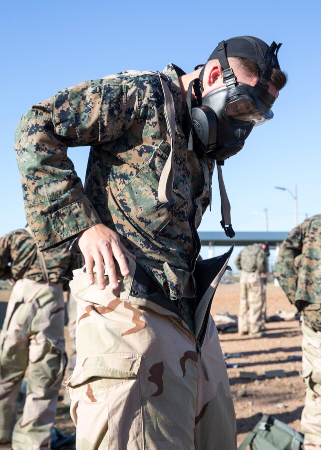 Cpl. Ashten Derickson, a cyber network operator with 3rd Marine Aircraft Wing, dons a Mission Oriented Protective Posture suit during the reconnaissance, surveillance and decontamination course at Marine Corps Air Station Miramar, Calif., March 25. The course is designed to train unit personnel in the procedures and equipment used in accomplishing RS&D operations in a chemical, biological, radiological or nuclear environment. (U.S. Marine Corps photo by Lance Cpl. Clare J. McIntire)