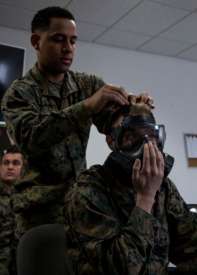 Cpl. Tyler Fares, and Cpl. Carlos Lopez, aviation operations specialists with 3rd Marine Aircraft Wing, adjusts the fit of Fares’ M50 Joint Service General Purpose Mask during the reconnaissance, surveillance and decontamination course at Marine Corps Air Station Miramar, Calif., March 25. The course is designed to train unit personnel in the procedures and equipment used in accomplishing RS&D operations in a chemical, biological, radiological or nuclear environment. (U.S. Marine Corps photo by Lance Cpl. Clare J. McIntire/Released)