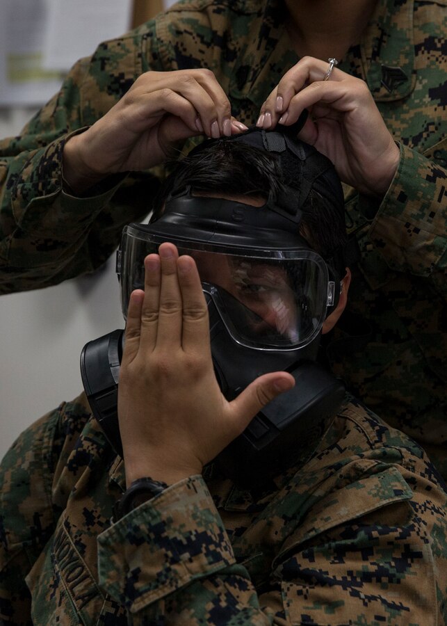 Sgt. Maria A. Noyola, a combat production specialist with 3rd Marine Aircraft Wing, adjusts the fit of her M50 Joint Service General Purpose Mask during the reconnaissance, surveillance and decontamination course at Marine Corps Air Station Miramar, Calif., March 25. The course is designed to train unit personnel in the procedures and equipment used in accomplishing RS&D operations in a chemical, biological, radiological or nuclear environment. (U.S. Marine Corps photo by Lance Cpl. Clare J. McIntire/Released)