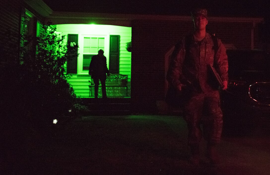 U.S. Air Force Airman 1st Class Nicholas Whitehurst, 633rd Communications Squadron client systems technician, departs for the airport as his mom, Amy, follows behind, illuminated by their green porch light in Hampton, Virginia, March 27, 2018.