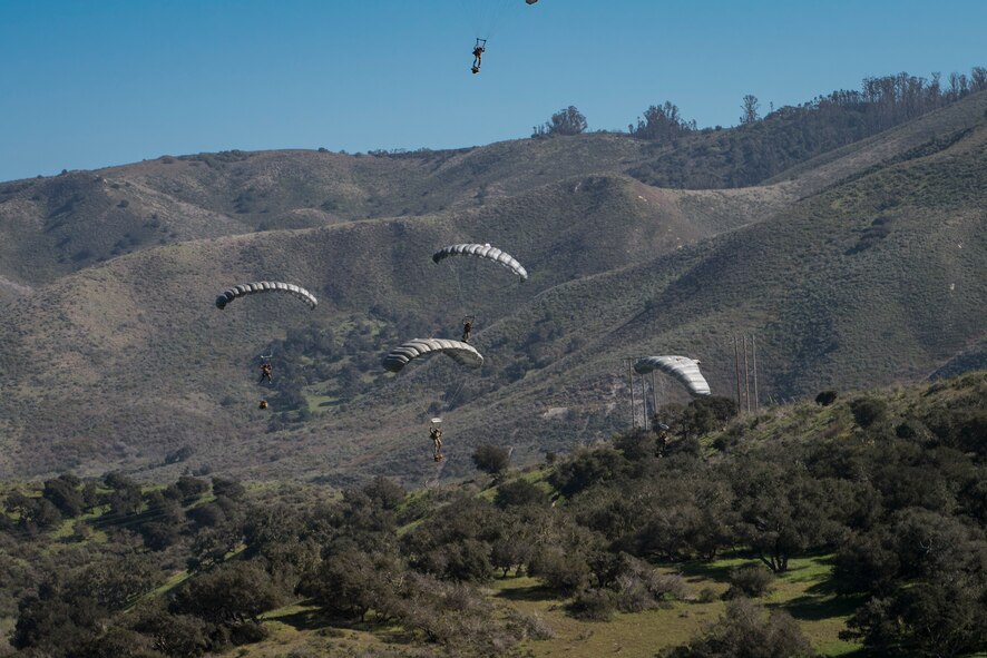 Pararescuemen from the 58th Rescue Squadron Nellis Air Force Base, Nev.,  descend onto a drop zone during Tiger Rescue IV, March 28, 2018, at Vandenberg Air Force Base, Calif. The four-day exercise challenged Airmen from multiple rescue squadrons to bring the capabilities of the personnel recovery triad together to successfully complete rescue missions and maintain proficiency. The three branches of the personnel recovery triad are the HC-130J Combat King II, HH-60G Pave Hawk and the guardian angel weapons system or pararescuemen. (U.S. Air Force photo by Senior Airman Janiqua P. Robinson)
