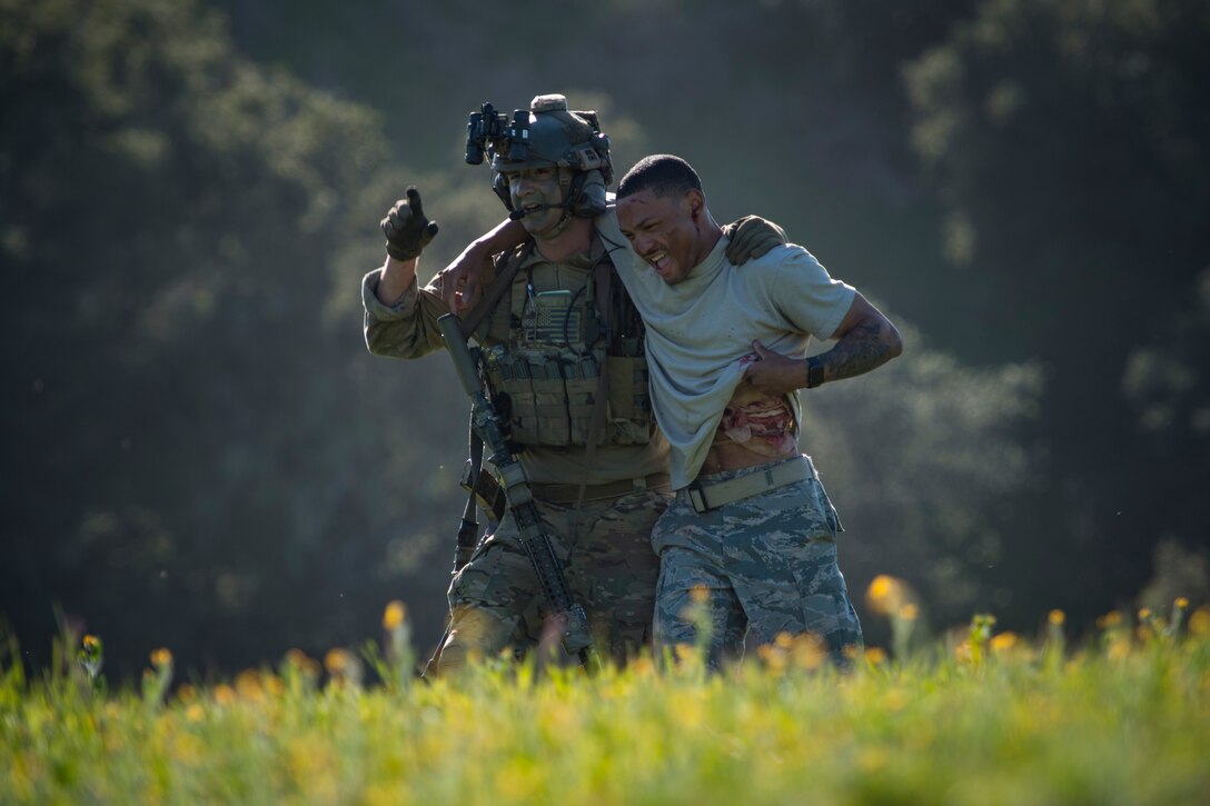 A pararescueman from the 58th Rescue Squadron, Nellis Air Force Base, Nev., helps a simulated casualty during Tiger Rescue IV, March 28, 2018, at Vandenberg Air Force Base, Calif. The four-day exercise challenged Airmen from multiple rescue squadrons to bring the capabilities of the personnel recovery triad together to successfully complete rescue missions and maintain proficiency. The three branches of the personnel recovery triad are the HC-130J Combat King II, HH-60G Pave Hawk and the guardian angel weapons system or pararescuemen. (U.S. Air Force photo by Senior Airman Janiqua P. Robinson)