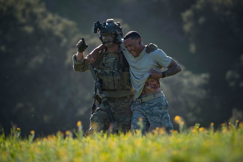 A pararescueman from the 58th Rescue Squadron, Nellis Air Force Base, Nev., helps a simulated casualty during Tiger Rescue IV, March 28, 2018, at Vandenberg Air Force Base, Calif. The four-day exercise challenged Airmen from multiple rescue squadrons to bring the capabilities of the personnel recovery triad together to successfully complete rescue missions and maintain proficiency. The three branches of the personnel recovery triad are the HC-130J Combat King II, HH-60G Pave Hawk and the guardian angel weapons system or pararescuemen. (U.S. Air Force photo by Senior Airman Janiqua P. Robinson)