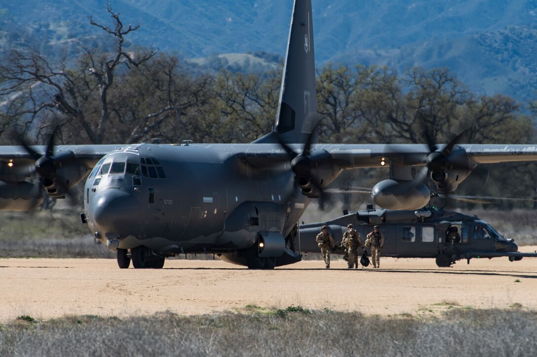 Pararescuemen from the 58th Rescue Squadron, Nellis Air Force Base, Nev., move a simulated casualty from an HH-60G Pave Hawk to an HC-130J Combat King II during Tiger Rescue IV, March 29, 2018, at Vandenberg Air Force Base, Calif. The four-day exercise challenged Airmen from multiple rescue squadrons to bring the capabilities of the personnel recovery triad together to successfully complete rescue missions and maintain proficiency. The three branches of the personnel recovery triad are the HC-130J, HH-60G and the guardian angel weapons system or pararescuemen. (U.S. Air Force photo by Senior Airman Janiqua P. Robinson)