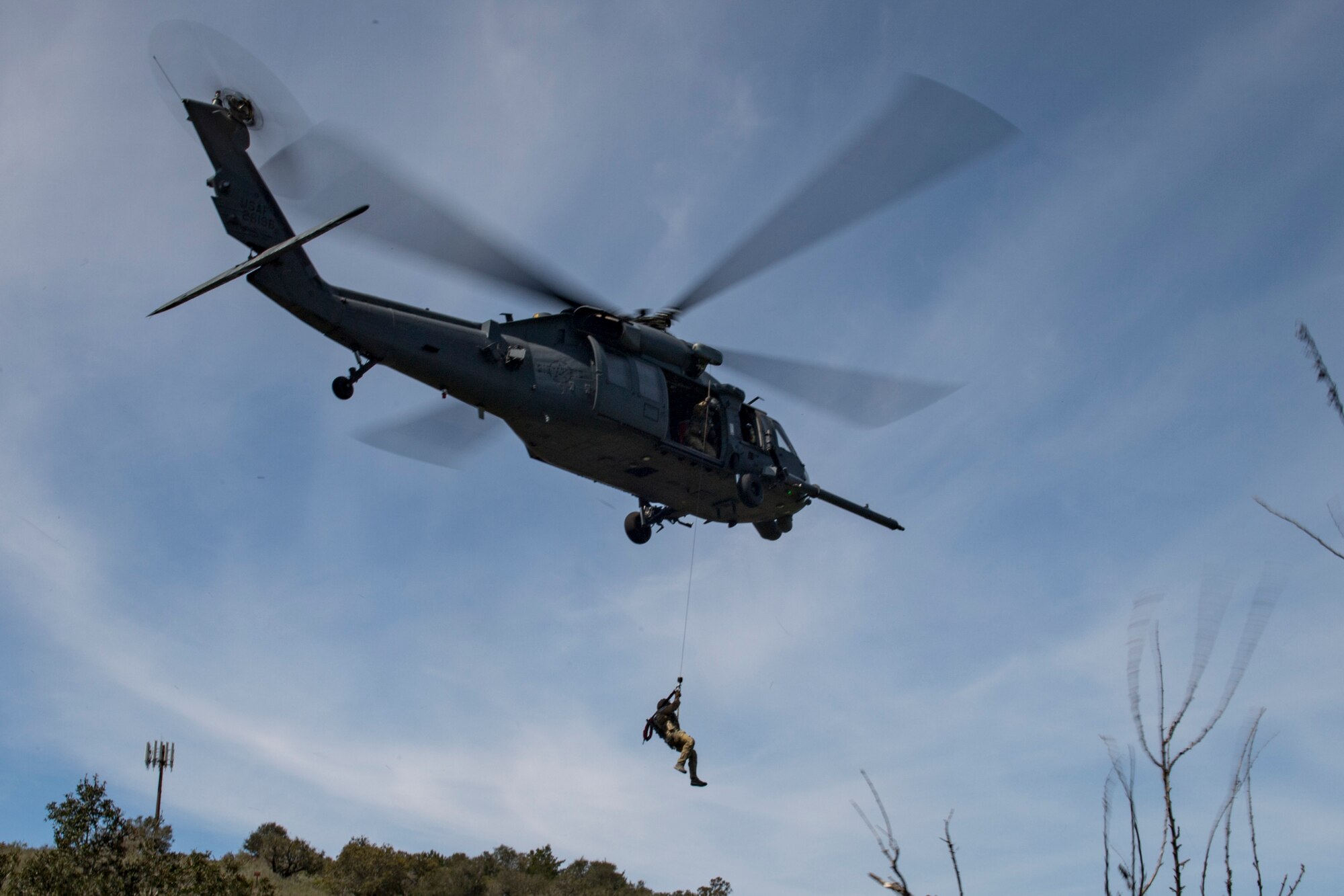 Airmen from the 55th Rescue Squadron, Davis-Monthan Air Force Base, Ariz., hoist a pararescueman from the 58th Rescue Squadron, Nellis Air Force Base, Nev., and a simulated casualty during Tiger Rescue IV, March 30, 2018, at Vandenberg Air Force Base, Calif. The four-day exercise challenged Airmen from multiple rescue squadrons to bring the capabilities of the personnel recovery triad together to successfully complete rescue missions and maintain proficiency. The three branches of the personnel recovery triad are the HC-130J, HH-60G and the guardian angel weapons system or pararescuemen. (U.S. Air Force photo by Tech. Sgt. Zachary Wolf)