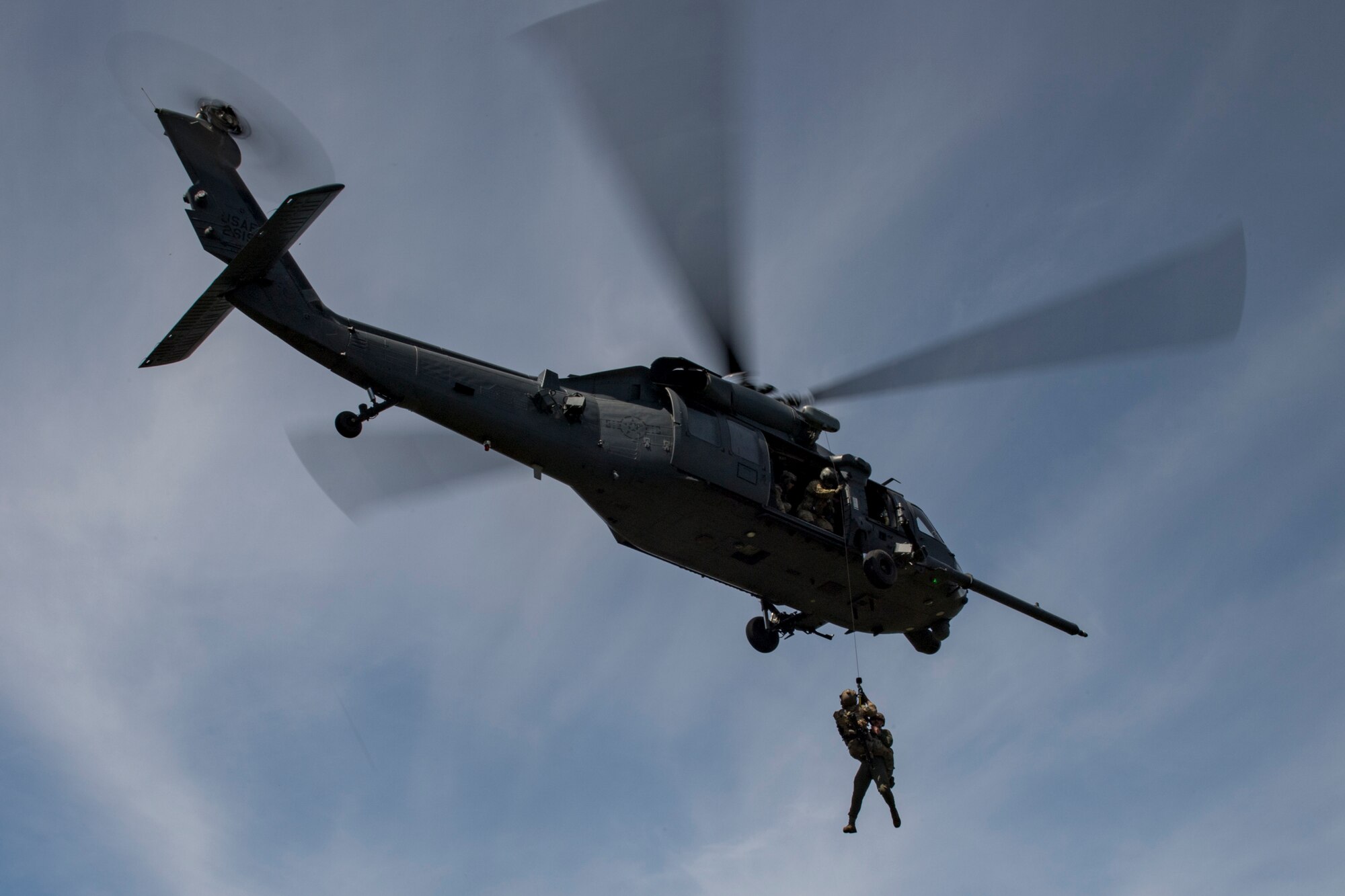 Airmen from the 55th Rescue Squadron, Davis-Monthan Air Force Base, Ariz., help a pararescueman from the 58th Rescue Squadron, Nellis Air Force Base, Nev., descend onto a drop zone during Tiger Rescue IV, March 30, 2018, at Vandenberg Air Force Base, Calif. The four-day exercise challenged Airmen from multiple rescue squadrons to bring the capabilities of the personnel recovery triad together to successfully complete rescue missions and maintain proficiency. The three branches of the personnel recovery triad are the HC-130J Combat King II, HH-60G Pave Hawk and the guardian angel weapons system or pararescuemen. (U.S. Air Force photo by Tech. Sgt. Zachary Wolf)