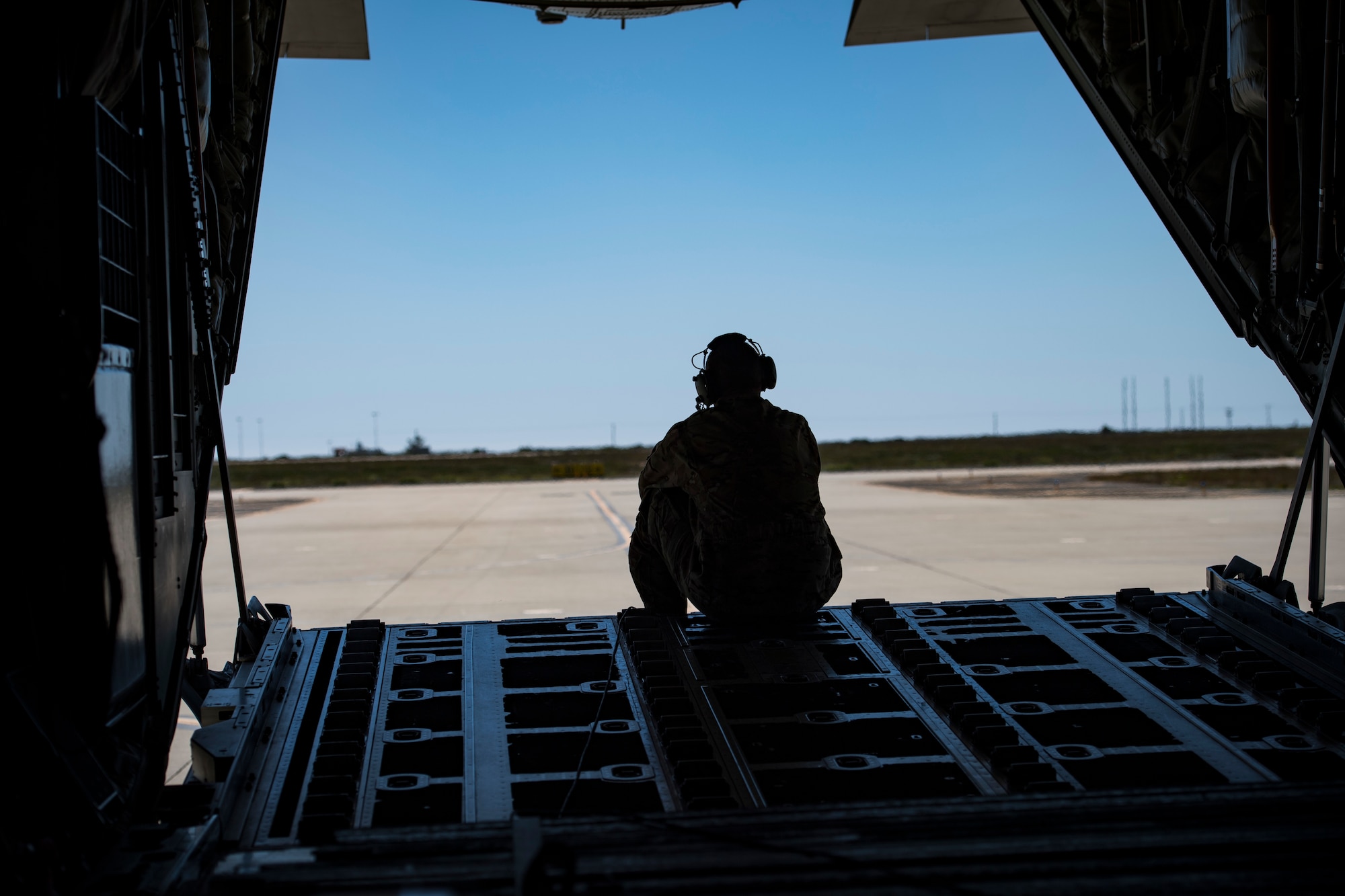 Tech. Sgt. Brandon Garbrick, 71st Rescue Squadron HC-130J Combat King II loadmaster, sits on the ramp of an HC-130J during Tiger Rescue IV, March 27, 2018, at Vandenberg Air Force Base, Calif. The four-day exercise challenged Airmen from multiple rescue squadrons to bring the capabilities of the personnel recovery triad together to successfully complete rescue missions and maintain proficiency. The three branches of the personnel recovery triad are the HC-130J, HH-60G Pave Hawk and the guardian angel weapons system or pararescuemen. (U.S. Air Force photo by Senior Airman Janiqua P. Robinson)