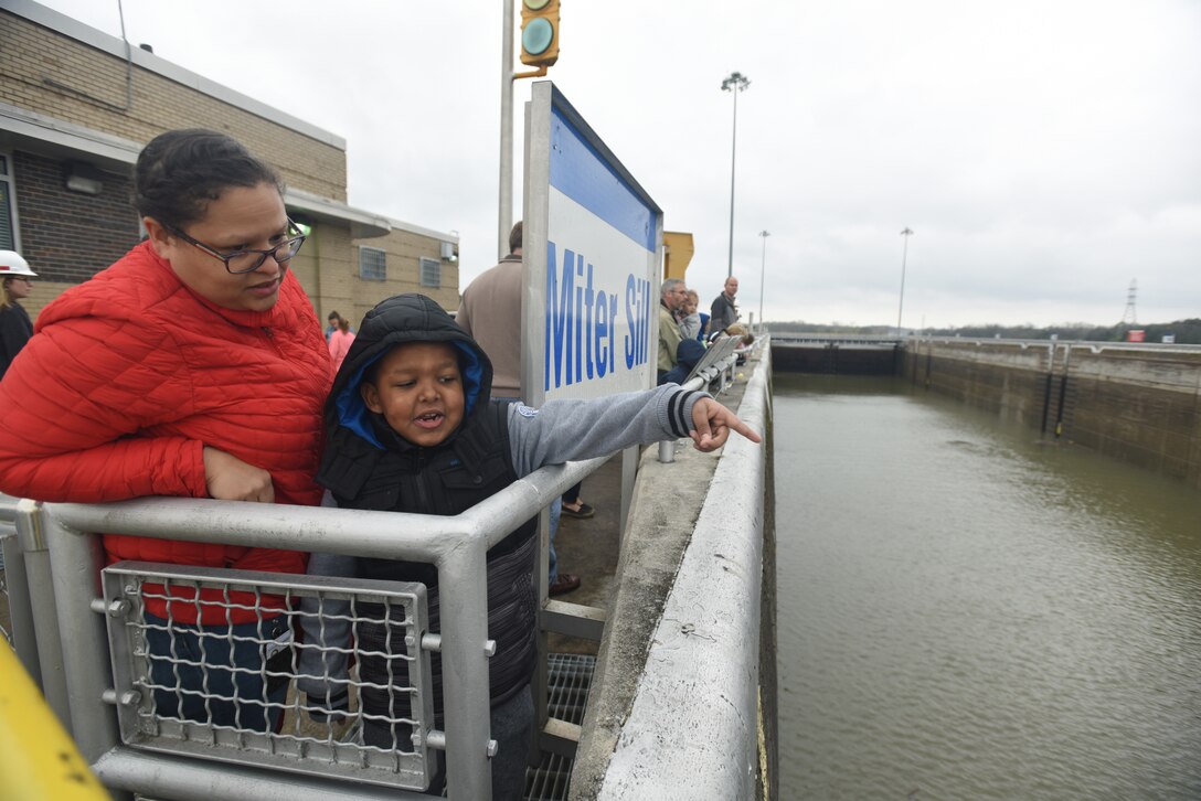 Camden Powell points toward the gates at Old Hickory Lock and asks his mom Janelle Powell, Resource Management budget analyst, questions about its operation.  They participated in the U.S. Army Corps of Engineers Nashville District “Bring Your Kids to Work Day” and toured Old Hickory Dam, Lock and Power House March 30, 2018. (USACE photo by Lee Roberts)