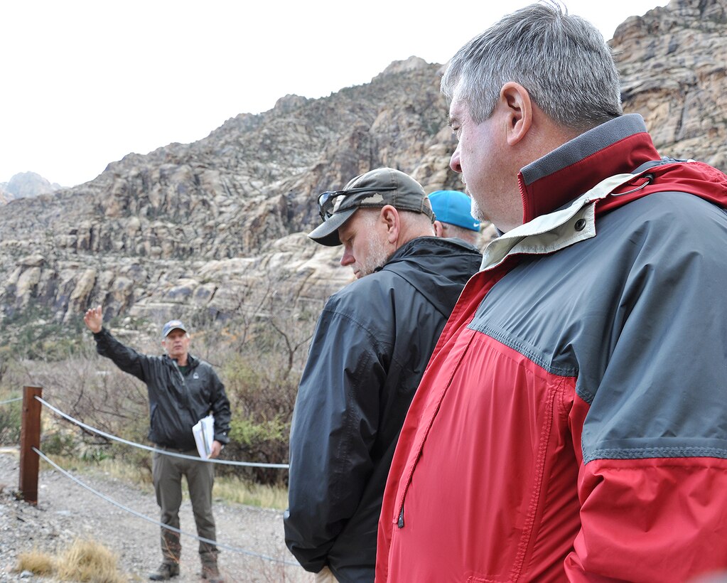 Keith Kelson, engineering geologist with the U.S. Army Corps of Engineers Sacramento District, background left, discusses how clues from pre-historic and historic floods can help predict future flooding events with other U.S. Army Corps of Engineers geologists during an exercise March 15 at the Red Rock Canyon National Conservation Area near Las Vegas.